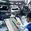 Mitarbeiter sitzt in der BMW-Fertigung an einem Touch-Bildschirm