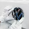 VW-Logo wird an Auto angebracht.