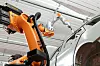 Roboterarm von Kuka arbeitet an der Karosserie eines Daimler-Autos