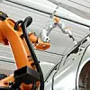 Roboterarm von Kuka arbeitet an der Karosserie eines Daimler-Autos