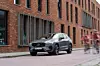 Ein Volvo XC60 Recharge steht in grau vor einem Backsteingebäude.