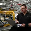 JLR schult seine Mitarbeiter in Sachen Data, um die Effizienz in der Produktion zu erhöhen. | Ein mann in einer Autofabrik vor einem Laptop.