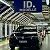Ein schwarzer Volkswagen ID.7 Tourer fährt im Werk Emden durch die Endkontrolle. Über dem Fahrzeug hängt ein Banner mit der Aufschrift ‚1,5 Millionen ID. Modelle