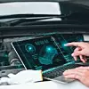 Mechanic working close to an automobile engine while using a laptop. A screen-based automotive diagnostic application. idea of a car service
