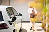 Close up of a electric car charger with female silhouette in the