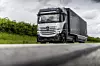 Der Mercedes-Benz GenH2 Truck auf einer Straße hinter einer Leitplanke.