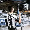 Audi-Mitarbeiter in der Montage erproben die Exoskelette beispielsweise beim Verschrauben der Unterbodenverkleidung.