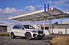 Der BMW iX5 Hydrogen steht vor einer Wasserstoff-Tankstelle. Das Pilotfahrzeug mit Brennstoffzelle könnte der Technologie einen Schub verleihen.
