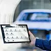Zwei Mitarbeiter von SAIC Volkswagen bedienen eine Applikation von Dürr auf dem Tablet in der chinesischen Lackiererei.