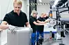 Auf dem Bild sind Mitarbeiter in der Montage für Energiespeicher von Mercedes-Benz zu sehen.
