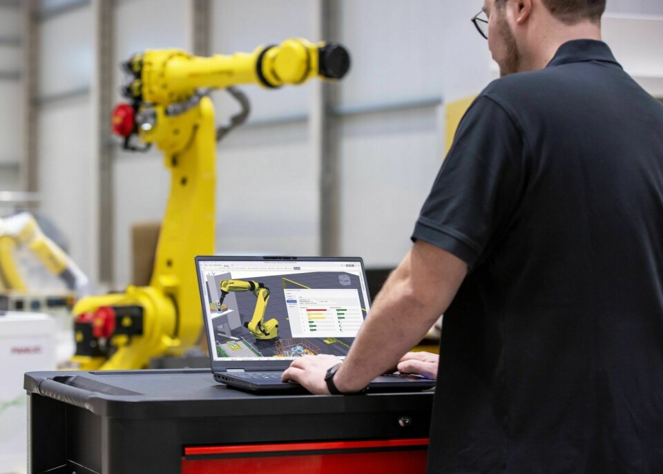 Fanuc, ABB, Kuka & Co.: Unterschiedlichste Roboterhersteller haben die Autoindustrie auch im Jahr 2024 beliefert und bei dessen Automatisierung unterstützt. „Ein Mann mit dunklem Polohemd steht vor einem Laptop und programmiert einen gelben Industrieroboter. Auf dem Bildschirm ist eine 3D-Simulation des Roboterarms mit Steuerungsdaten zu sehen. Im Hintergrund befindet sich die Produktionshalle.