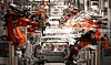 Mehrere Industrieroboter montieren Karosserien auf einer automatisierten Fertigungslinie.