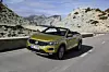 EIn gelber Volkswagen T-Roc Cabriolet auf einer bergigen Strecke.