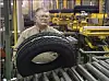 Ein Mitarbeiter bei der Qualitätskontrolle bei einem Goodyear Dunlop Reifen.