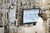 Ein Mitarbeiter von Bosch steht in der Produktion vor einem großen Bildschirm.