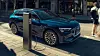 blauer Audi e-Tron seitlich von vorne rechts aufgenommen, an einer Ladesäule in der Stadt