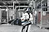 Humanoid robot AEON carrying a large car body panel inside a BMW factory.