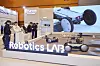 Ausstellungsstand von Hyundai Robotics Lab mit mobilen Robotern und Besuchern in Messehalle