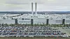 Luftaufnahme des Volkswagen-Werks in Zwickau mit großen Produktionshallen, zwei Schornsteinen und einem weitläufigen Parkplatz voller Fahrzeuge.