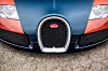 Frontansicht eines Bugatti mit typischem Kühlergrill und Logo auf gepflastertem Boden.