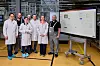 Mitarbeitende von Aumovio im Frankfurter Werk vor einem Bildschirm mit dem Virtual Line Information Board zur digitalen Steuerung von Produktionsprozessen.