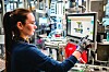 Mitarbeiterin bedient einen Bildschirm an einer automatisierten Produktionsanlage von Bosch.