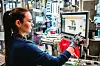 Mitarbeiterin bedient einen Bildschirm an einer automatisierten Produktionsanlage von Bosch.