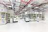 Produktionshalle der PowerCo-Gigafabrik in Salzgitter mit automatisierten Fertigungsanlagen für Batteriezellen und Mitarbeitenden in Reinraumkleidung.