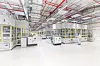 Produktionshalle der PowerCo-Gigafabrik in Salzgitter mit automatisierten Fertigungsanlagen für Batteriezellen und Mitarbeitenden in Reinraumkleidung.