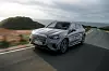 Silberner elektrischer Mercedes-Benz GLC 400 4MATIC fährt auf einer kurvigen Küstenstraße an der Algarve in Portugal.