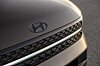 Nahaufnahme der Front eines Hyundai-Autos mit Logo, Kühlergrill und lackierter Motorhaube.