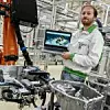 Škoda-Mitarbeiter mit Laptop vor neuer Roboter-Installation