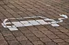 Ein Symbol für einen Parkplatz für E-Autos auf Kopfsteinpflastern.