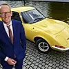 Opel-Chef Karl-Thomas Neumann ist auf dem Bild zu sehen. Im Hintergrund ein gelber Opel-Oldtimer.
