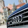 Audi-Motorhaube, im Hintergrund sind Gebäude einer Stadt zu sehen.