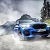 Ein blauer BMW X1 PHEV fährt über die ländliche Straße um eine Kurve.